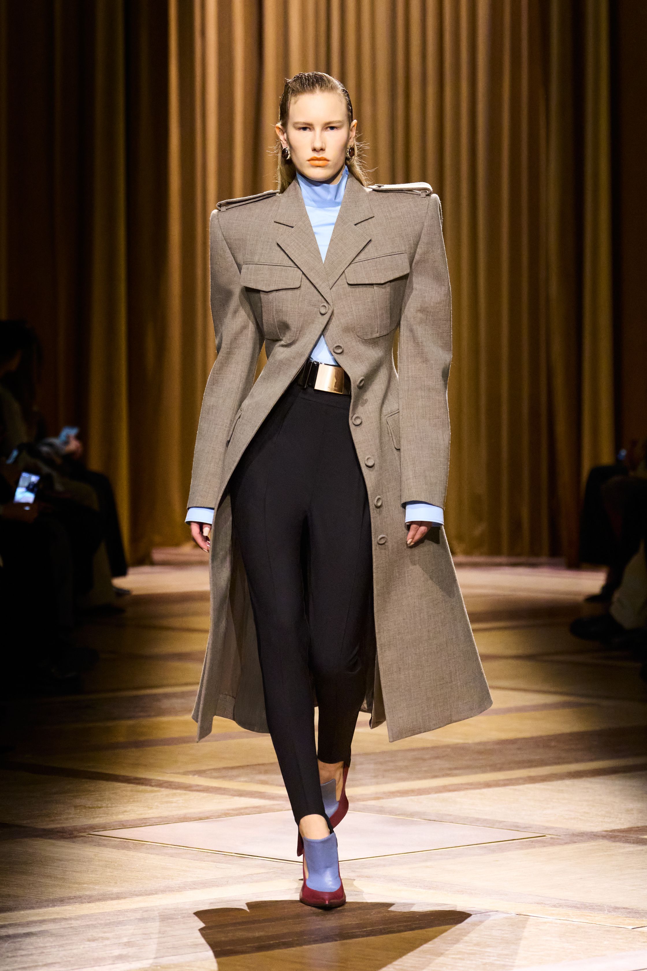 Mugler 本季继续强化品牌最核心的雕塑性感：极端肩线、收紧腰部与流畅长裤塑造出未来感女性轮廓。紫色权力套装、金属光泽衬衫和皮革裙装让整场秀既强势又华丽，仿佛科幻电影中的都市女主角-顽石频道趋势研究